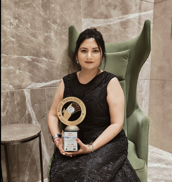 Sneha Bansod seated with the Maharashtra Business Award trophy