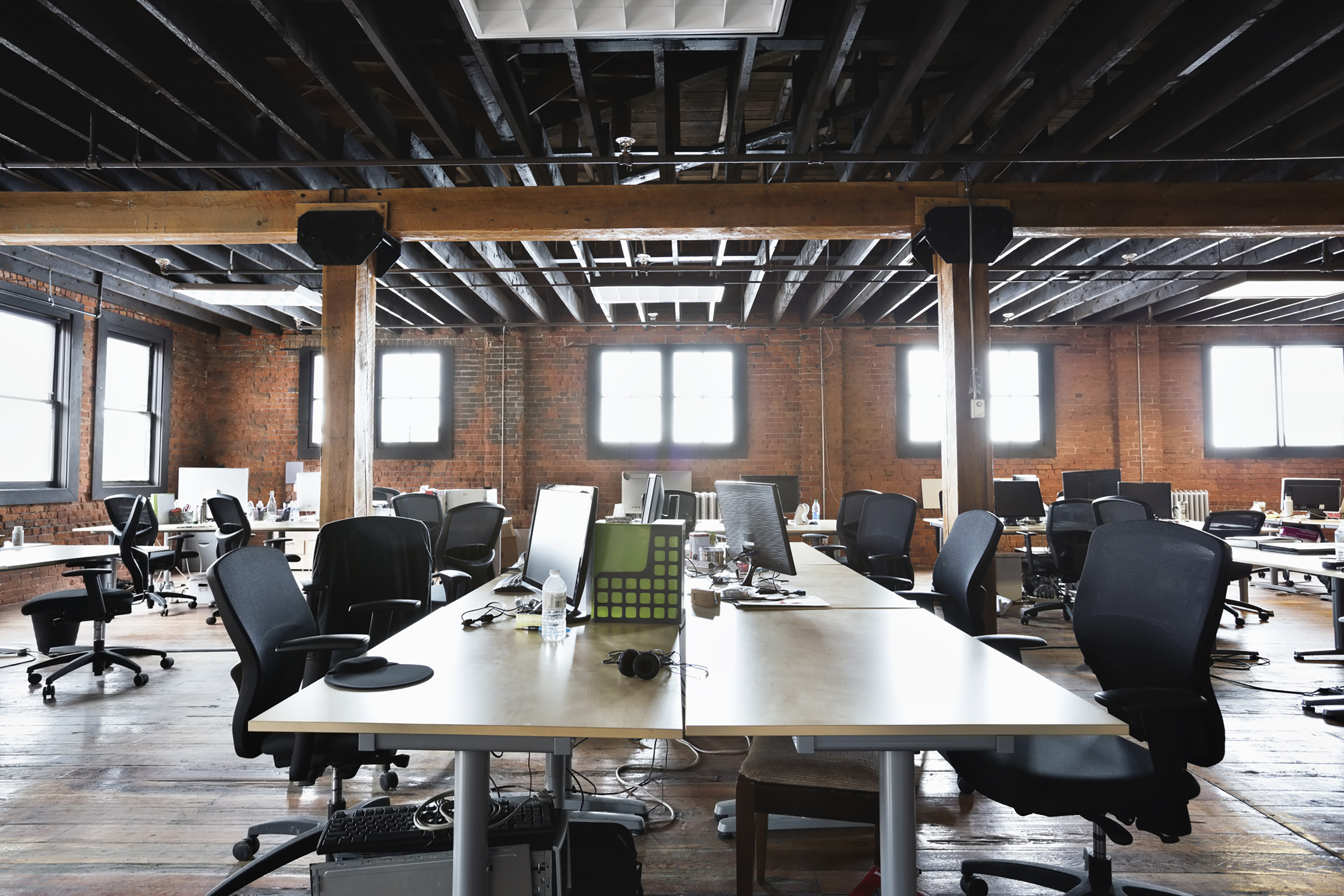 Commercial office interior with long meeting desk and exposed ceiling